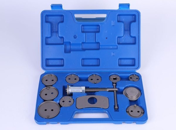 Open blue blow-molded case displaying the complete 12-piece brake caliper wind-back tool set, showing the main tool and various adapter plates.