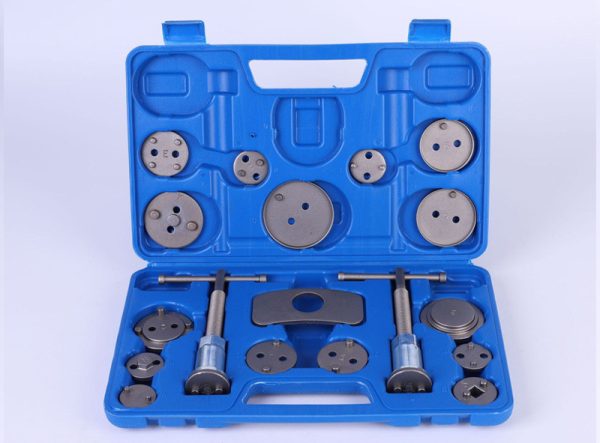 Open blue blow-molded case displaying the complete 18-piece brake caliper wind-back tool set, highlighting the two main tools and numerous adapter plates.