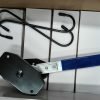 Angled view of the blue-handled compact ratcheting brake spreader showing the black contact plates.