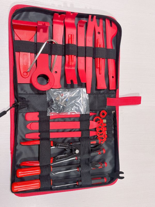 Top-down view of the 45-piece master kit laid out, highlighting the spring-loaded airbag pullers, metal pry bars, and the wire puller loop.