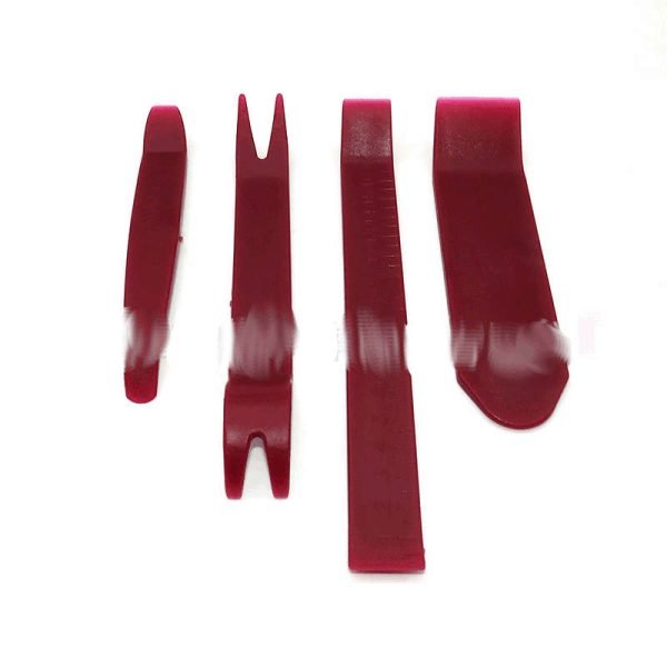 Set of four red plastic car interior trim removal pry tools including a curved bar, wide scraper, forked clip remover and long straight pry bar on a white background.