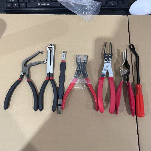 A 7-piece automotive pliers set laid out flat on cardboard, featuring red and black handles and various precision jaws.
