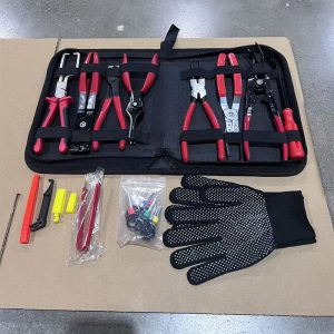 An open view of the Ultimate 8-Piece Automotive Pliers Set showing red-handled pliers, a terminal removal kit, and safety gloves laid out on cardboard.