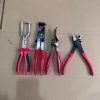 An overhead view of the 11-piece deluxe auto repair kit featuring pure red handle pliers, nylon trim removal tools, and electrical terminal extractors in a zippered case.