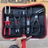 An overhead view of the 11-piece deluxe auto repair kit featuring pure red handle pliers, nylon trim removal tools, and electrical terminal extractors in a zippered case.