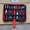 An overhead view of the 11-piece deluxe auto repair kit featuring pure red handle pliers, nylon trim removal tools, and electrical terminal extractors in a zippered case.