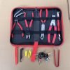 An overhead view of the 11-piece deluxe auto repair kit featuring pure red handle pliers, nylon trim removal tools, and electrical terminal extractors in a zippered case.