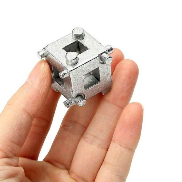 Close-up of the silver 34mm multi-functional brake wind-back adapter cube held in a hand to show scale.