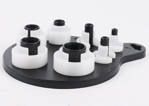 Seven piece white and black plastic fuel line disconnect tool set on a hanging board, sizes from 1/4 inch to 7/8 inch, used for removing car AC and fuel line quick connectors.
